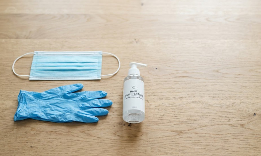 Einwegmaske, Handschuhe und Desinfektionsmittel als Pflegehilfsmittel zum Verbrauch